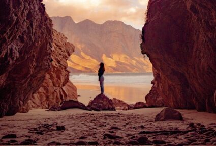 une femme regarde le ciel dans un paysage minéral pour illustrer sa médiumnité